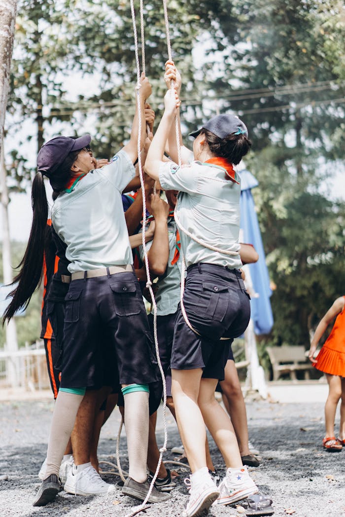 Teenagers collaborate in an outdoor teamwork exercise, showcasing leadership and cooperation.