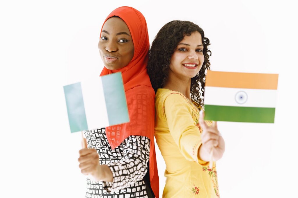 pexels photo 8770973 Two women from Nigeria and India holding their flags, symbolizing unity and diversity.